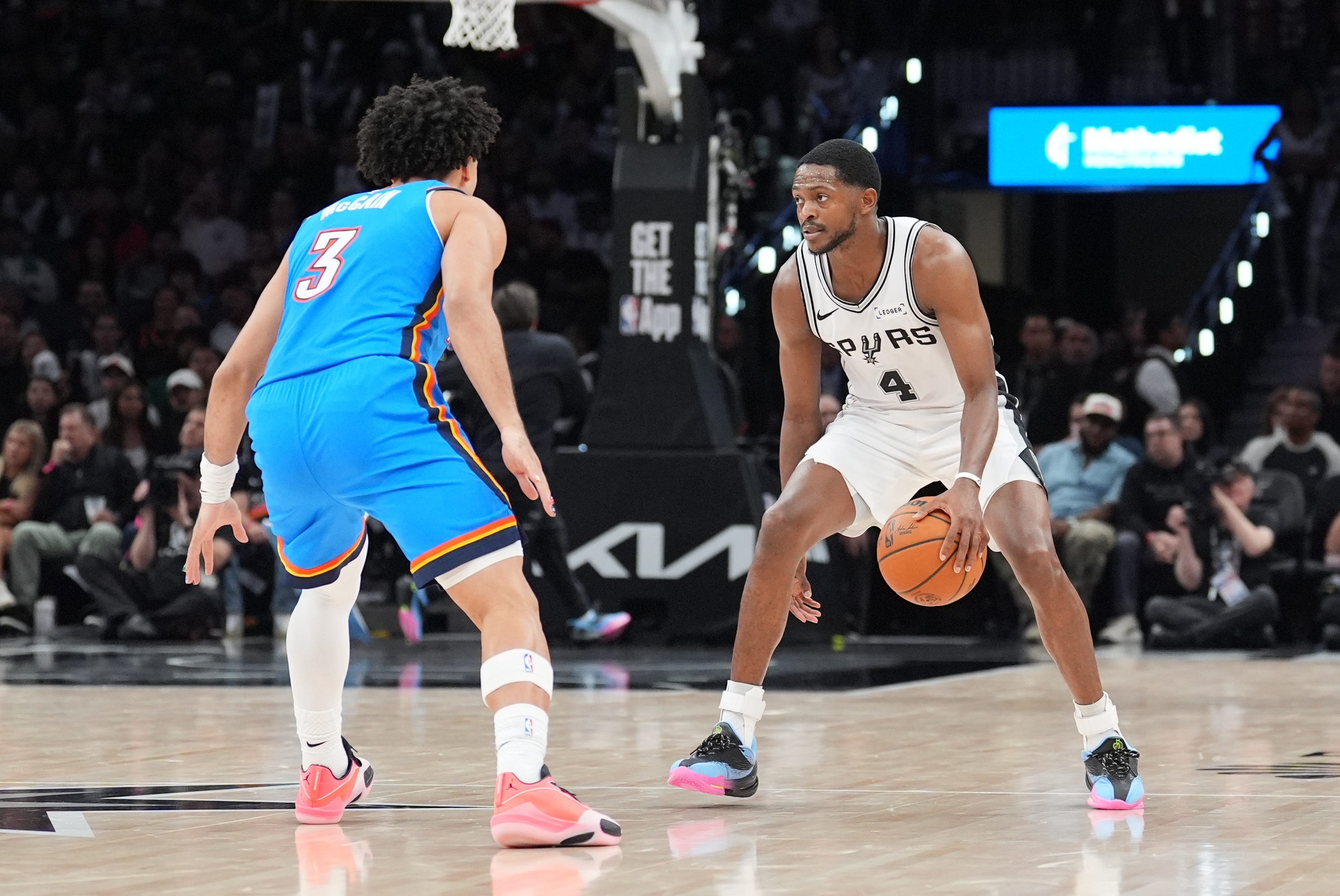 Oct 20, 2026; San Antonio, Texas, USA;  San Antonio Spurs guard De'aaron Fox (4) dribbles in front of Oklahoma City Thunder guard Jared McCain (3) in the second half at Frost Bank Center.  Mandatory Credit: Daniel Dunn-Imagn Images
