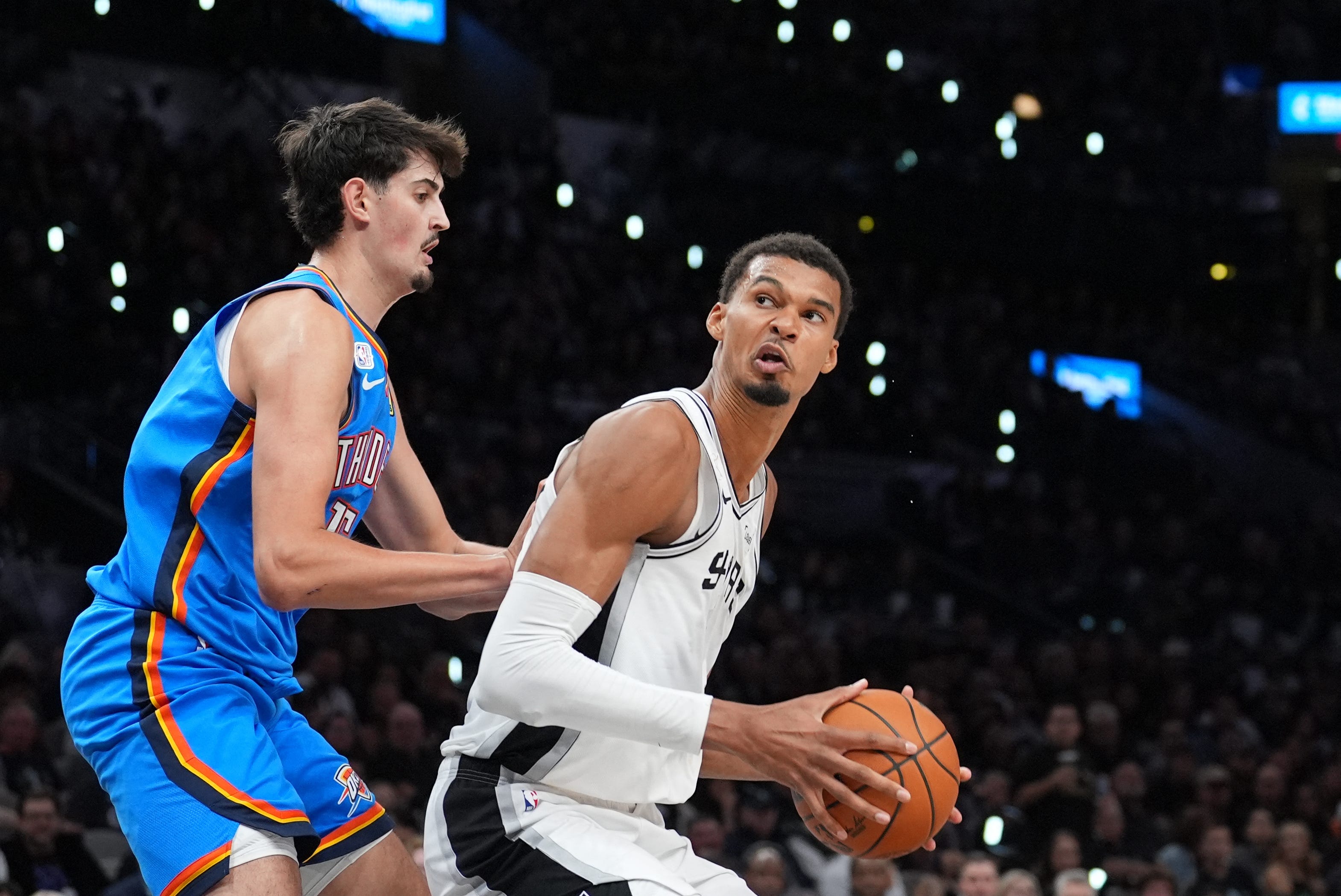 Oct 20, 2026; San Antonio, Texas, USA;  San Antonio Spurs forward Victor Wembanyama (1) drives against Oklahoma City Thunder center Aday Mara (15) in the second half at Frost Bank Center.  Mandatory Credit: Daniel Dunn-Imagn Images