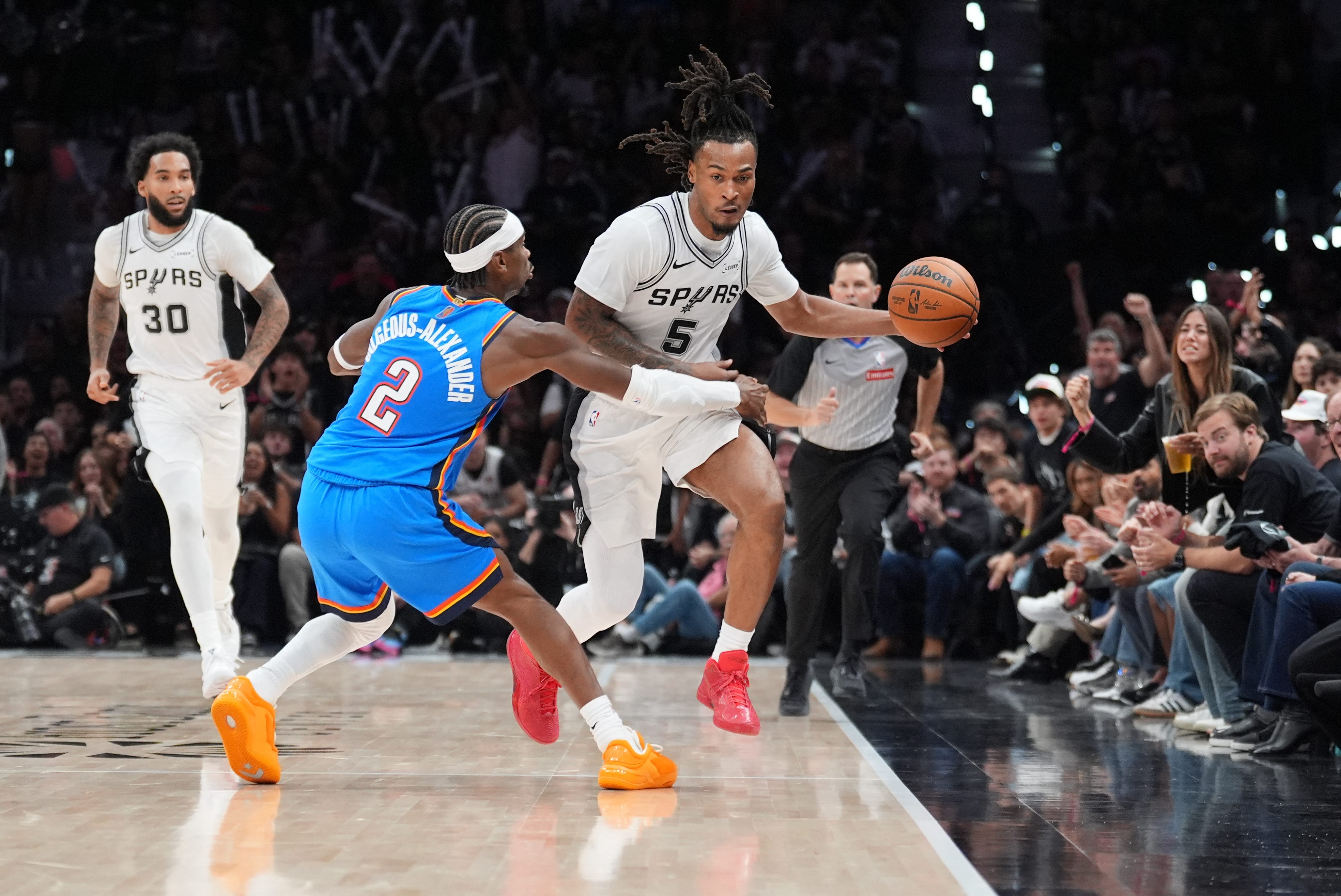 Oct 20, 2026; San Antonio, Texas, USA;  San Antonio Spurs guard Stephon Castle (5) dribbles against Oklahoma City Thunder guard Shai Gilgeous-Alexander (2) in the second half at Frost Bank Center.  Mandatory Credit: Daniel Dunn-Imagn Images