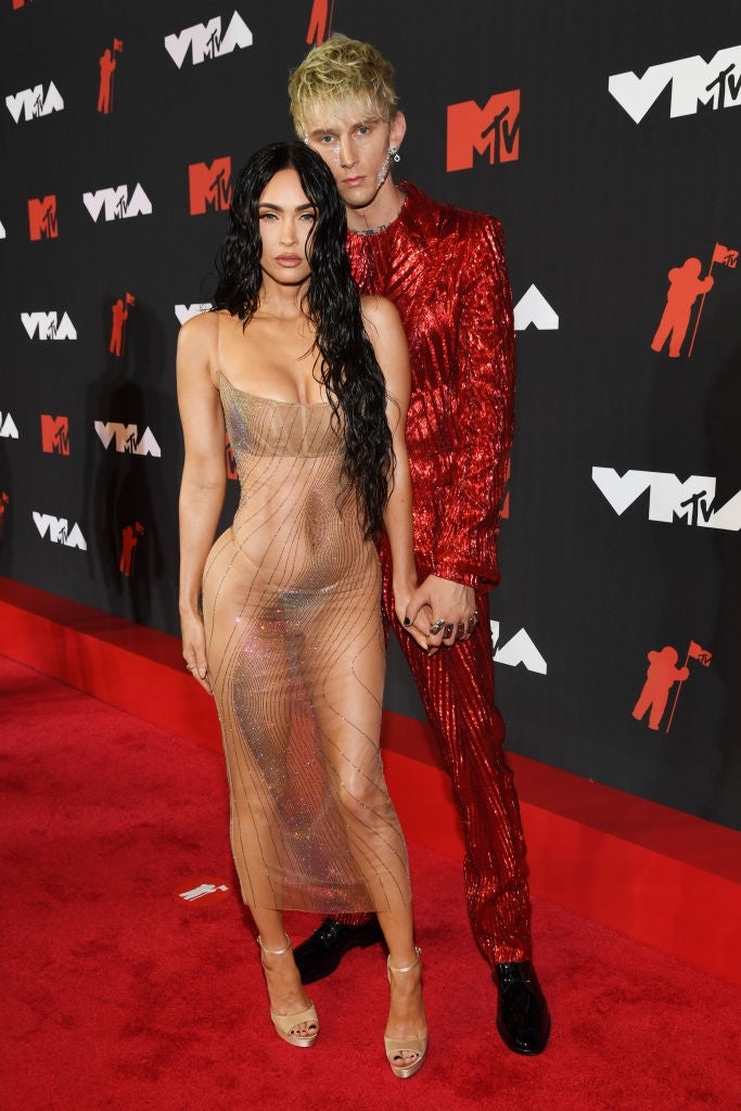 megan in a sheer dress with a sparkly design, and mgk in a glittery suit