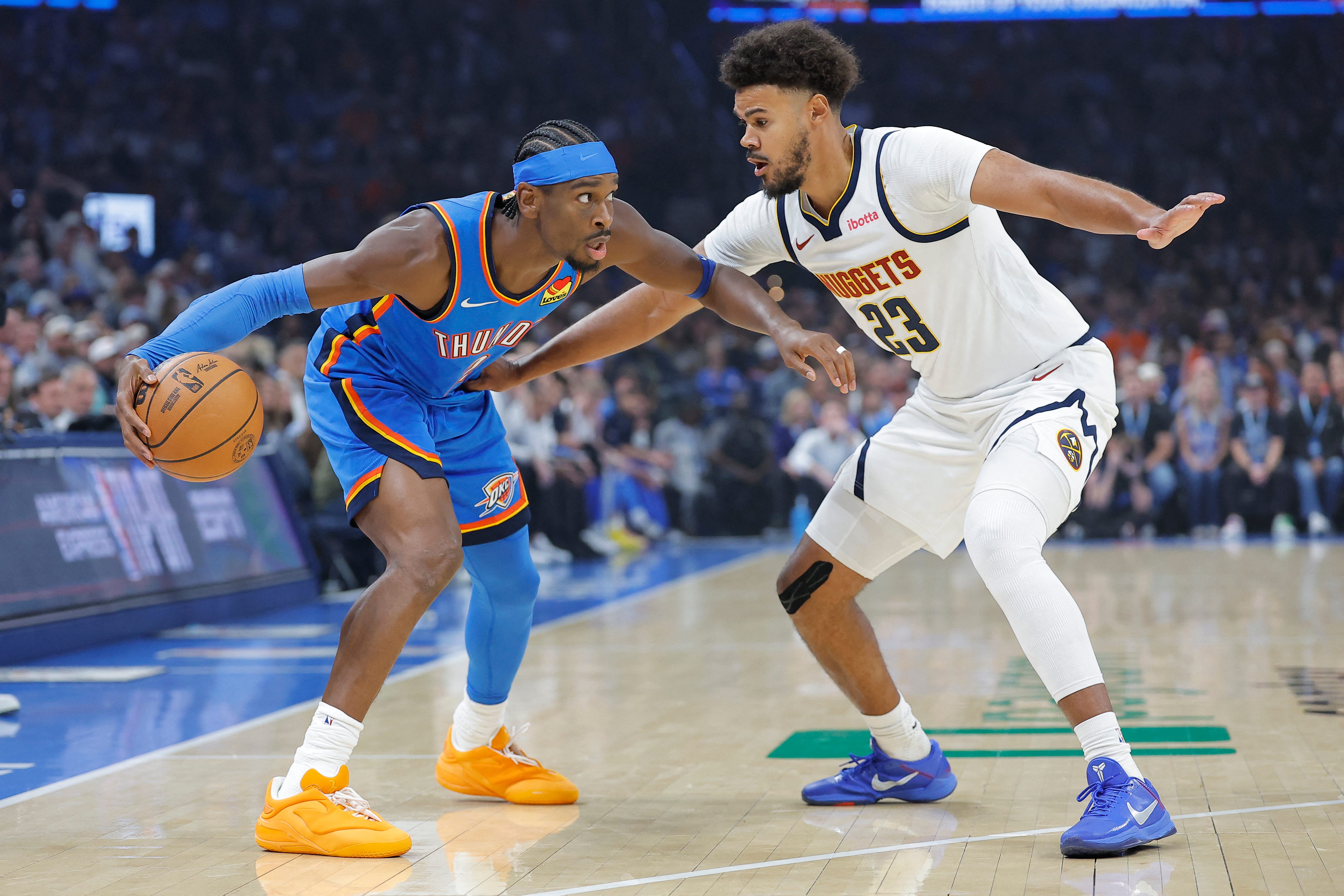 Oct 22, 2026; Oklahoma City, Oklahoma, USA; Oklahoma City Thunder guard Shai Gilgeous-Alexander (2) moves the ball around Denver Nuggets forward Cameron Johnson (23) during the first quarter at Paycom Center. Mandatory Credit: Alonzo Adams-Imagn Images