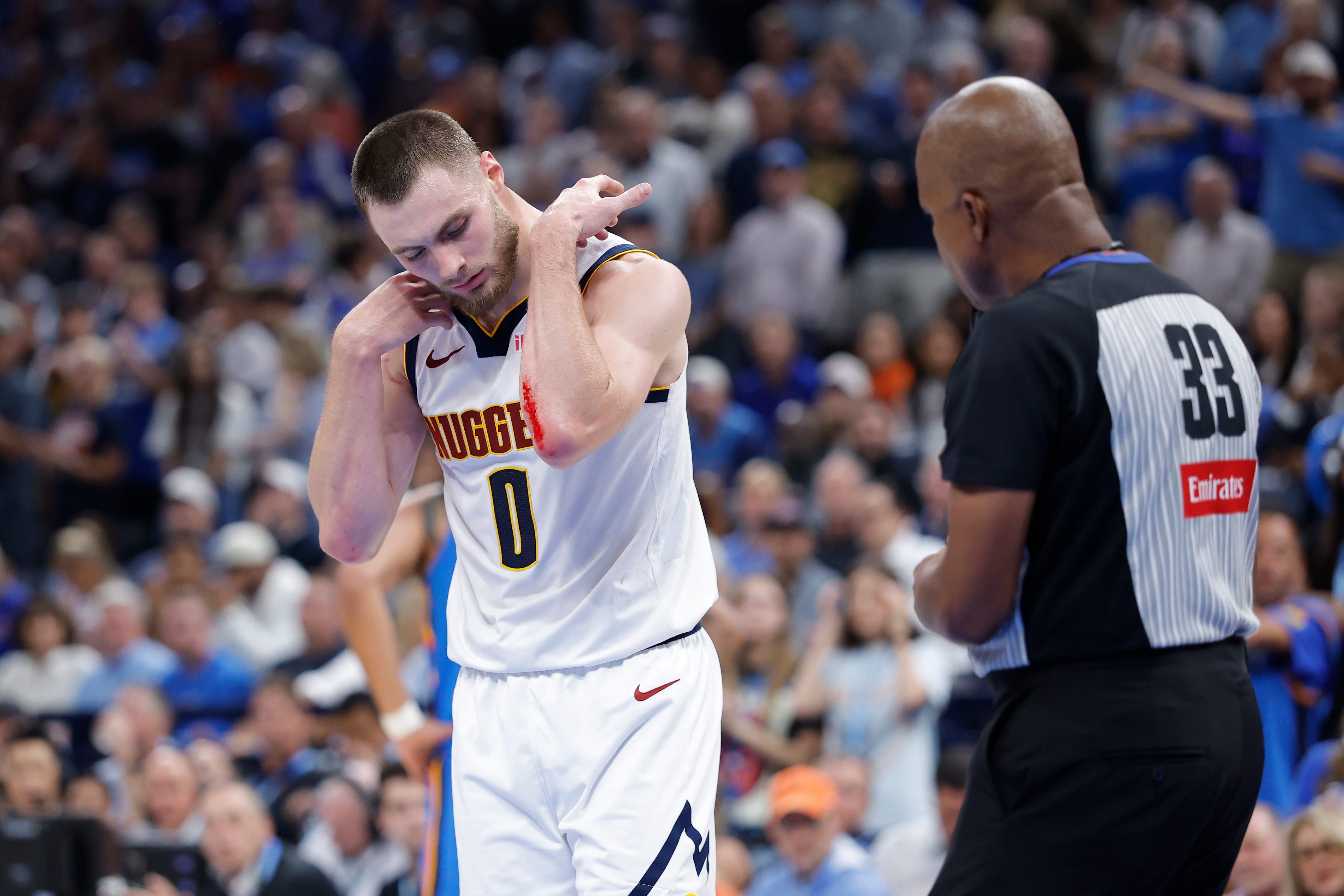 Oct 22, 2026; Oklahoma City, Oklahoma, USA; Denver Nuggets guard Christian Braun (0) and an official look at his arm after a play against the Oklahoma City Thunder during the second half at Paycom Center. Mandatory Credit: Alonzo Adams-Imagn Images