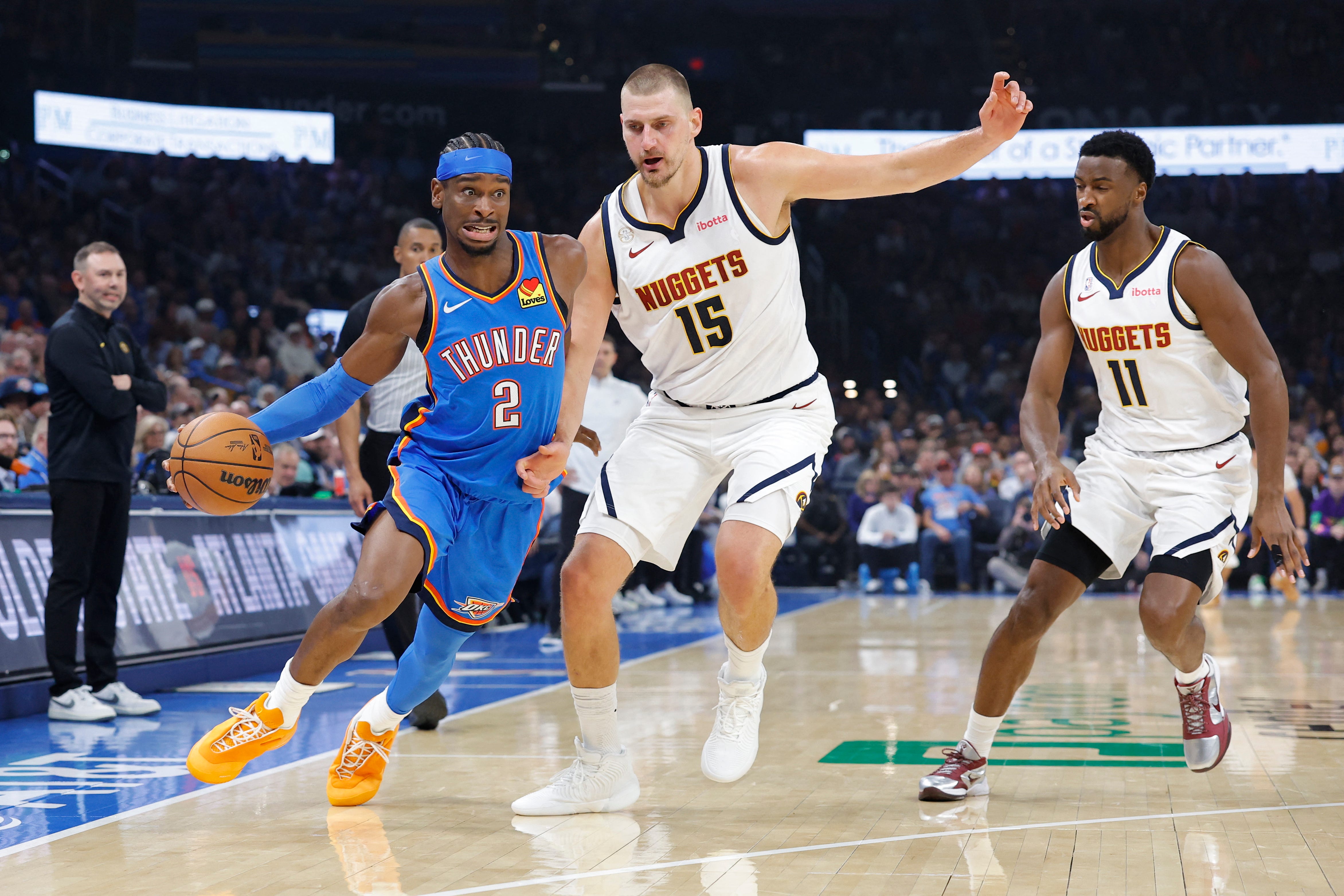 Oct 22, 2026; Oklahoma City, Oklahoma, USA; Oklahoma City Thunder guard Shai Gilgeous-Alexander (2) drives past Denver Nuggets center Nikola Jokic (15) during the first half at Paycom Center. Mandatory Credit: Alonzo Adams-Imagn Images