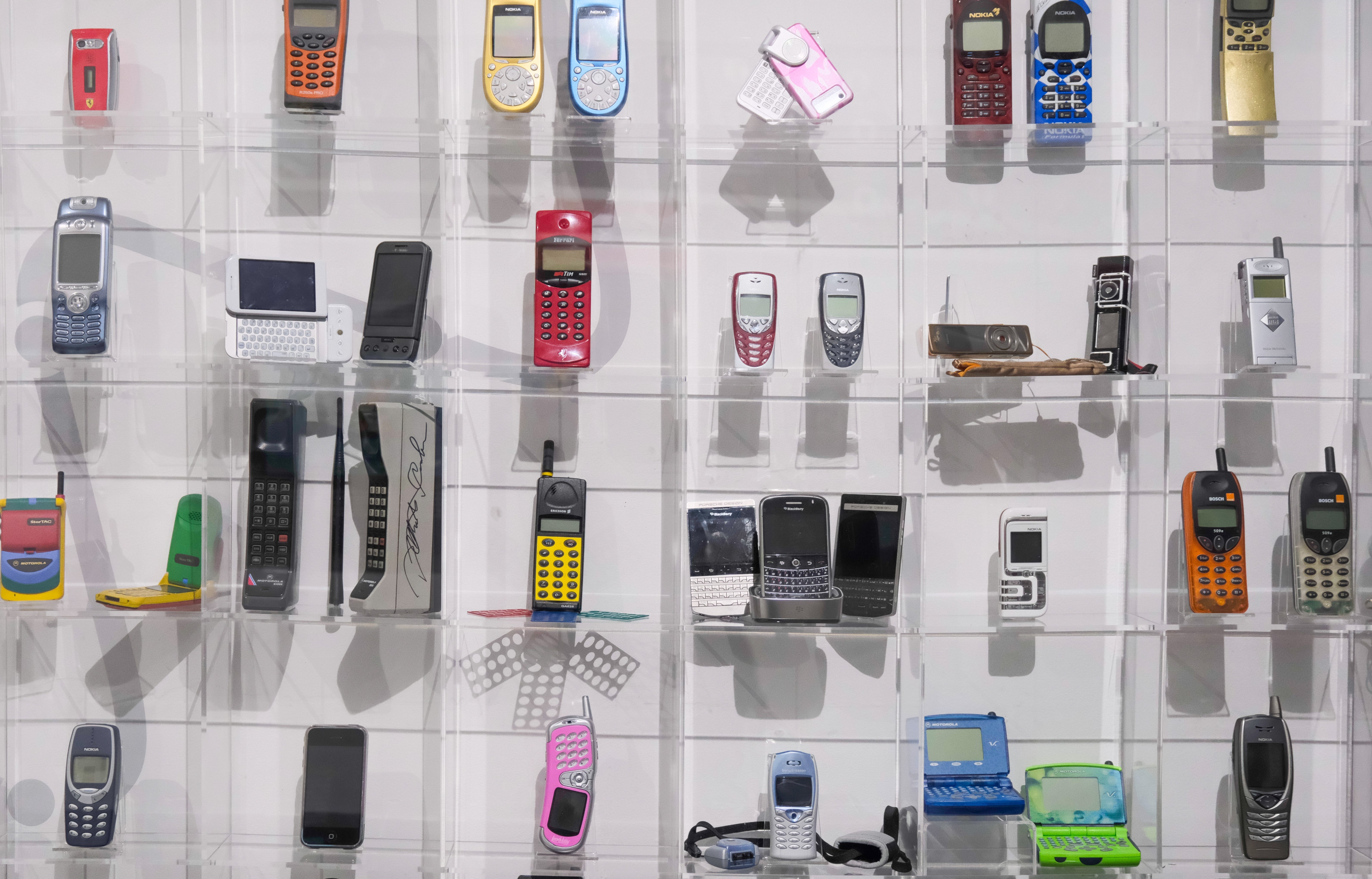 A display of vintage cell phones features different models and styles, highlighting the evolution of mobile technology over time.
