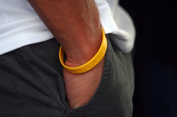 Person's hand in pocket with yellow livestrong bracelet