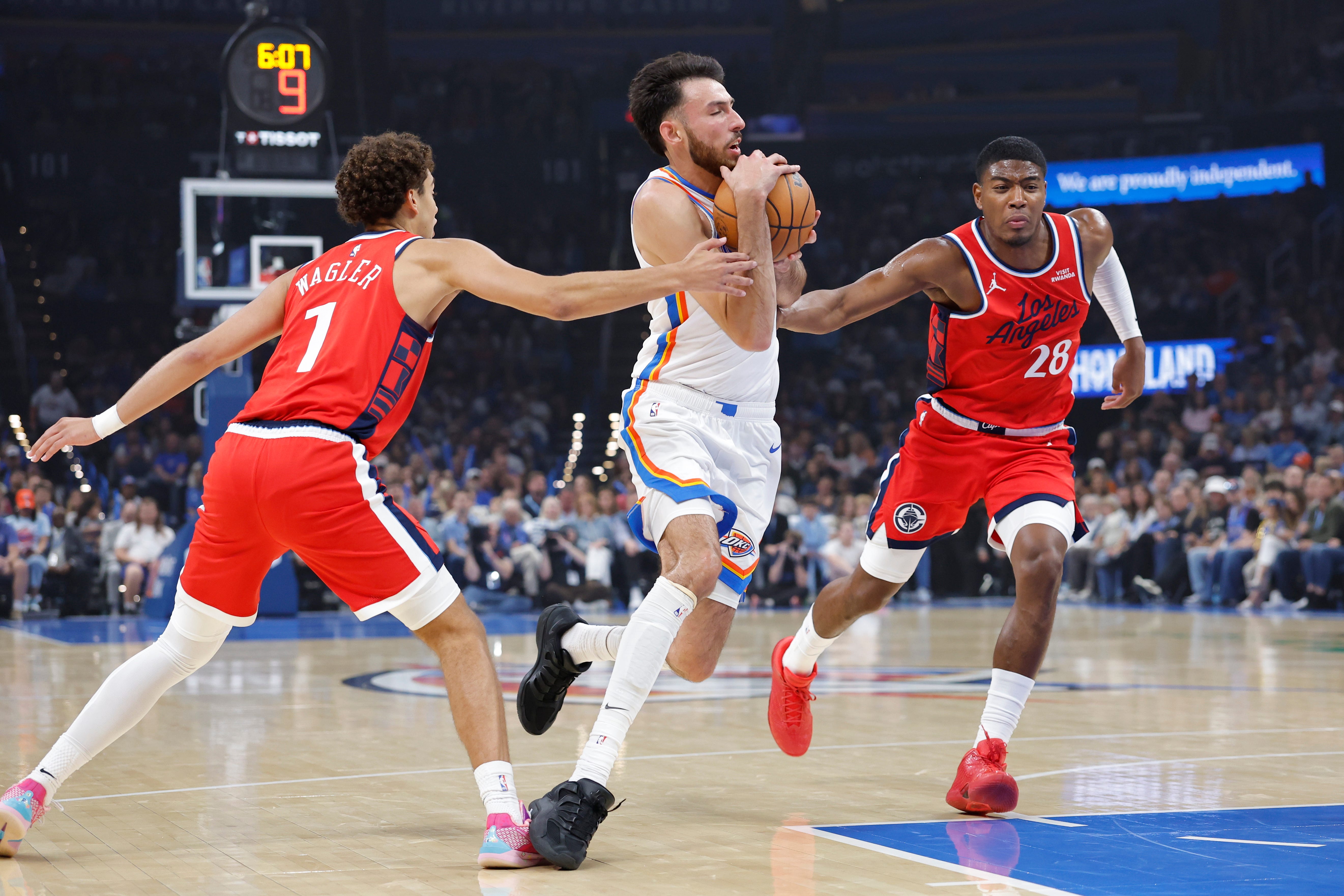 Oct 25, 2026; Oklahoma City, Oklahoma, USA; Oklahoma City Thunder center Chet Holmgren (7) drives between Los Angeles Clippers guard Keaton Wagler (1) and forward Rui Hachimura (28) during the first half at Paycom Center. Mandatory Credit: Alonzo Adams-Imagn Images