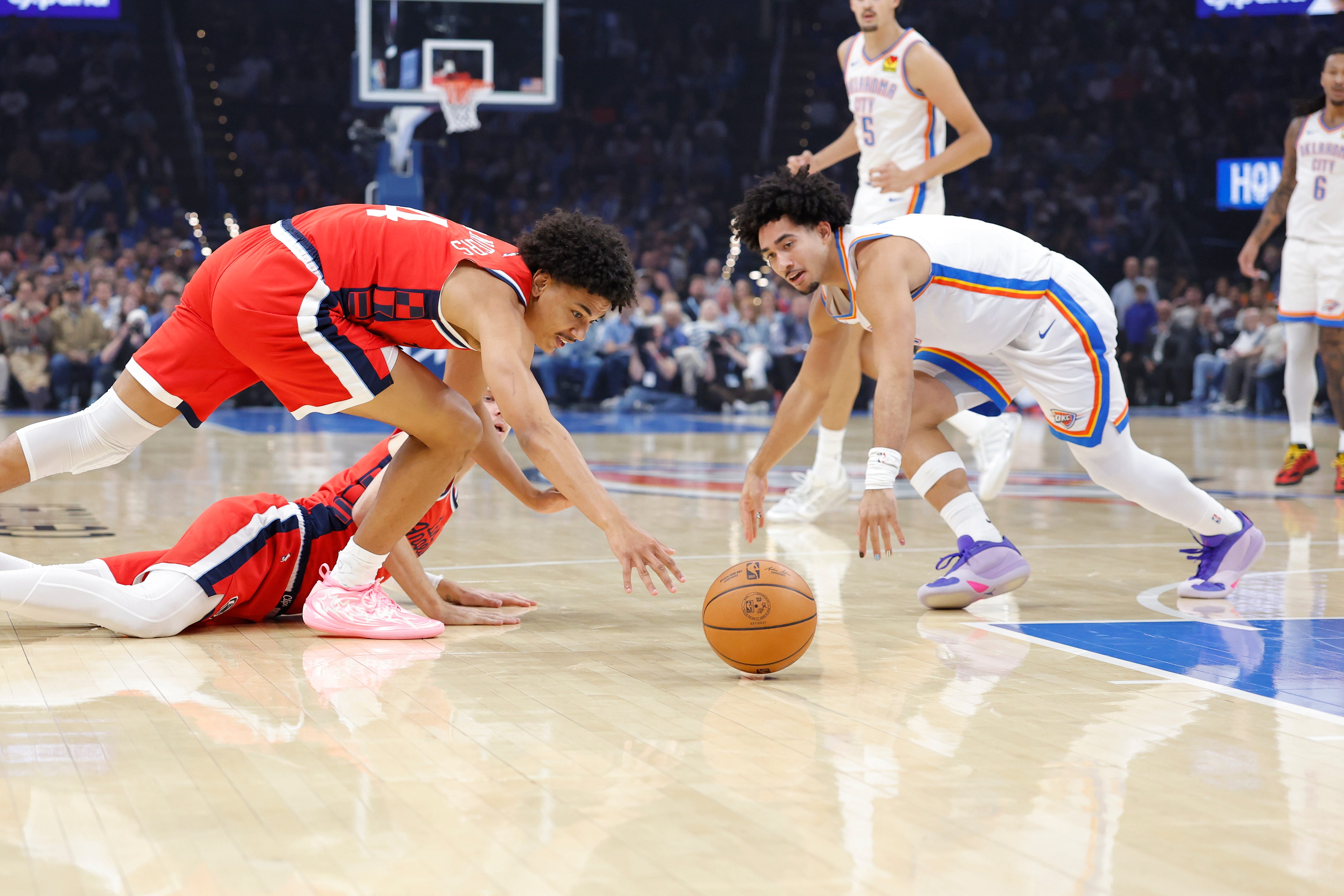 Oct 25, 2026; Oklahoma City, Oklahoma, USA; Los Angeles Clippers guard Kobe Sanders (4) and Oklahoma City Thunder guard Jared McCain (3) reach for a loose ball during the first half at Paycom Center. Mandatory Credit: Alonzo Adams-Imagn Images