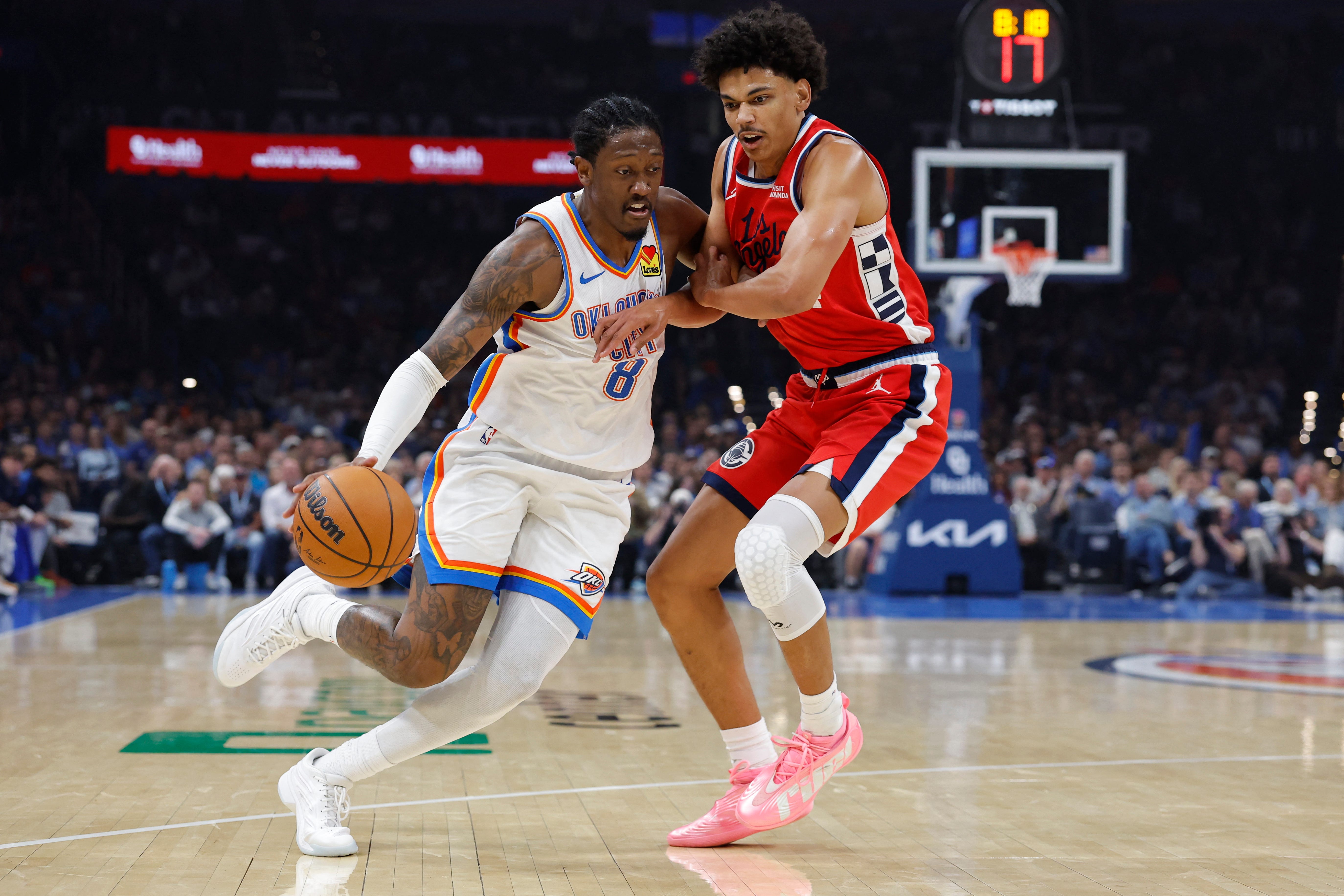 Oct 25, 2026; Oklahoma City, Oklahoma, USA; Oklahoma City Thunder guard Jalen Williams (8) drives past Los Angeles Clippers guard Kobe Sanders (4) during the first half at Paycom Center. Mandatory Credit: Alonzo Adams-Imagn Images