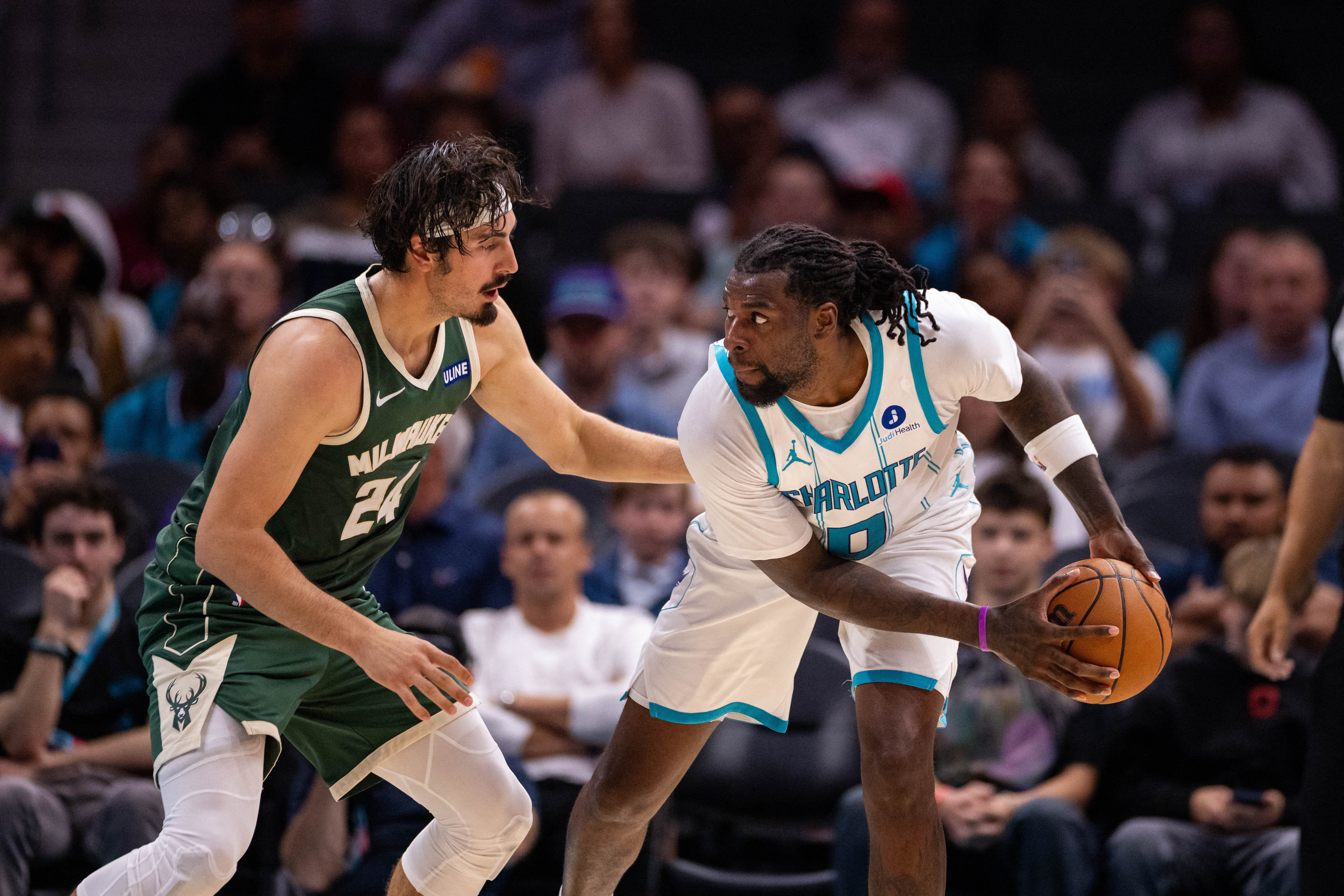 Oct 11, 2026; Charlotte, North Carolina, USA;  Charlotte Hornets center Naz Reid (0) gets pressured by Milwaukee Bucks forward Jaime Jaquez Jr. (24) during the second half at Spectrum Center.  Mandatory Credit: Scott Kinser-Imagn Images