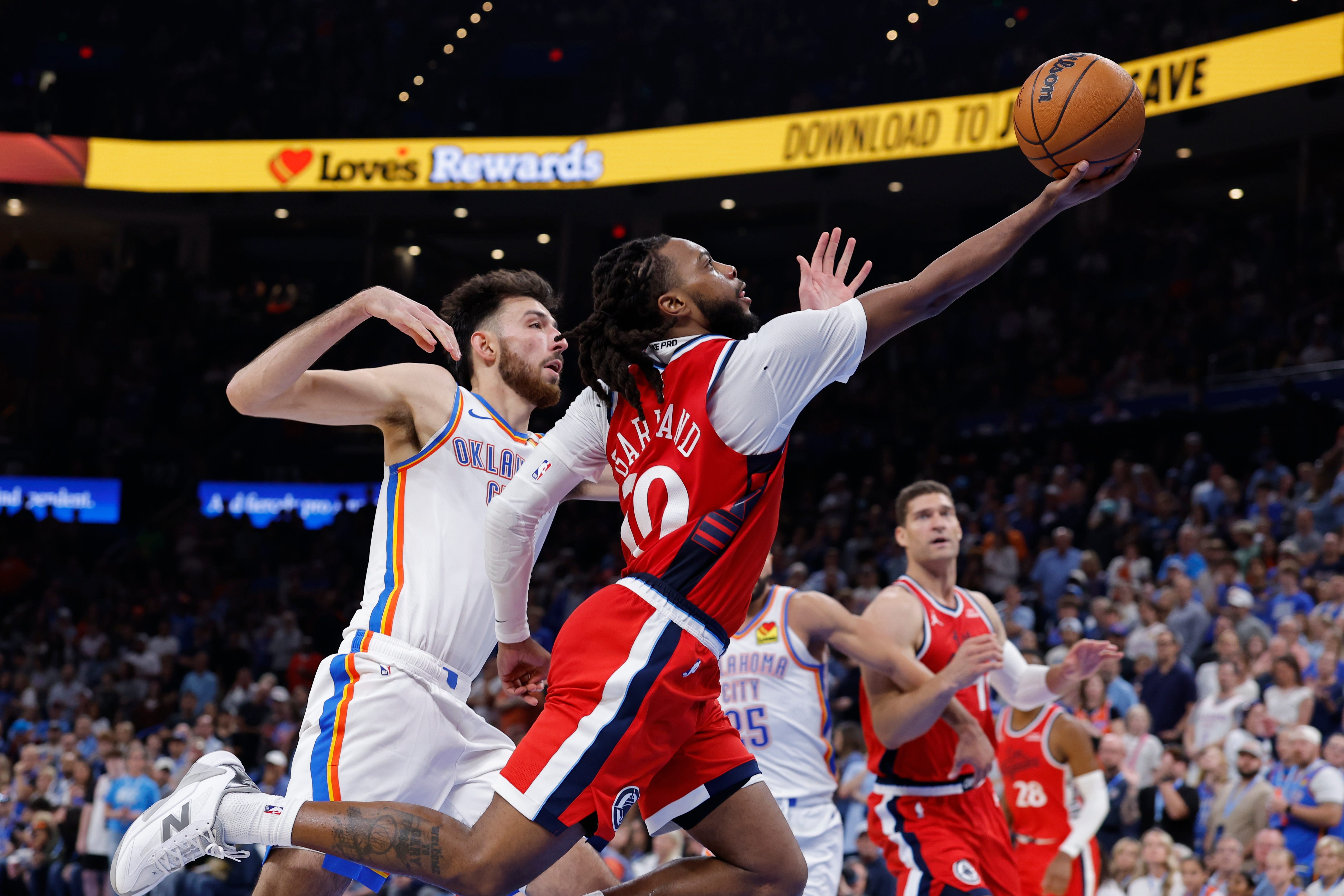 Oct 25, 2026; Oklahoma City, Oklahoma, USA; Los Angeles Clippers guard Darius Garland (10) goes up for a basket beside Oklahoma City Thunder center Chet Holmgren (7) during the second half at Paycom Center. Mandatory Credit: Alonzo Adams-Imagn Images