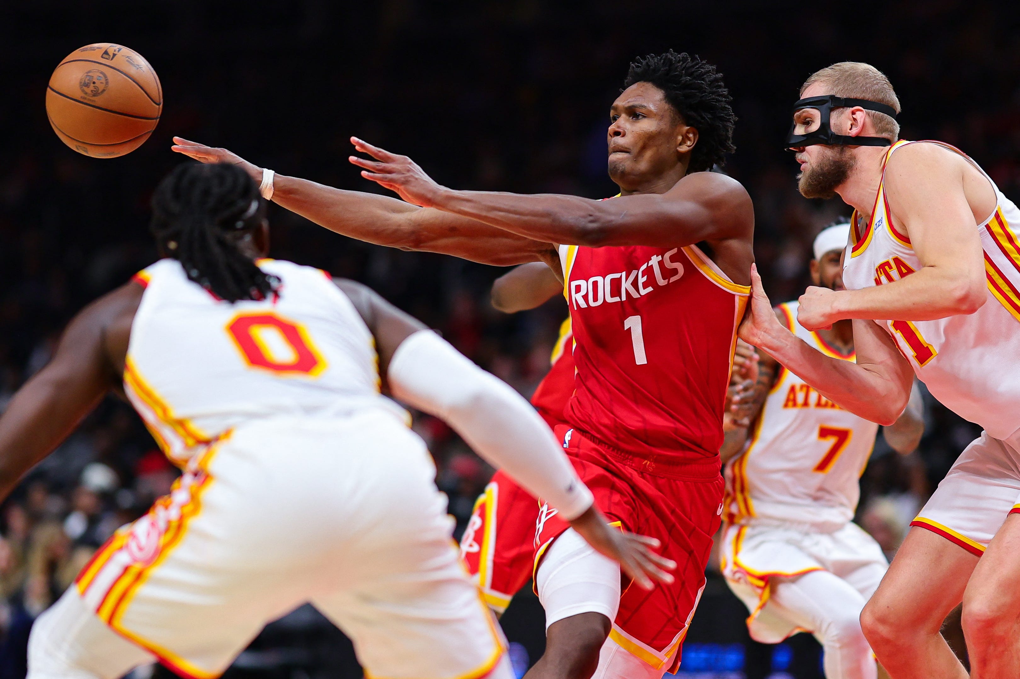 Oct 24, 2026; Atlanta, Georgia, USA;  Houston Rockets guard Amen Thompson (1) passes against Atlanta Hawks guard Luguentz Dort (0) and Atlanta Hawks center Jock Landale (31) in the third quarter at State Farm Arena.  Mandatory Credit: Colin Hubbard-Imagn Images
