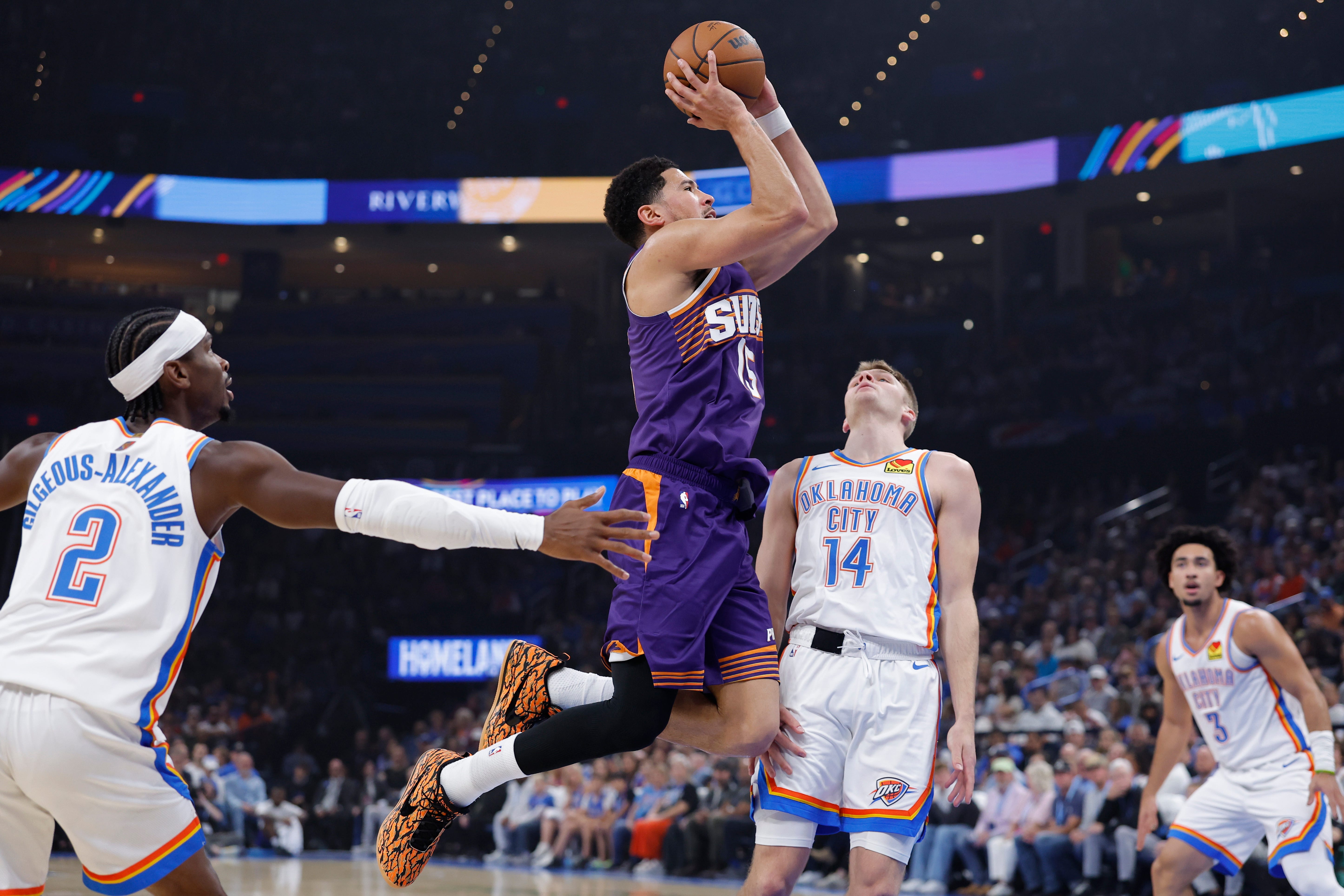 Oct 26, 2026; Oklahoma City, Oklahoma, USA; Phoenix Suns guard Devin Booker (15) shoots between Oklahoma City Thunder guard Shai Gilgeous-Alexander (2) and guard Bennett Stirtz (14) during the first half at Paycom Center. Mandatory Credit: Alonzo Adams-Imagn Images