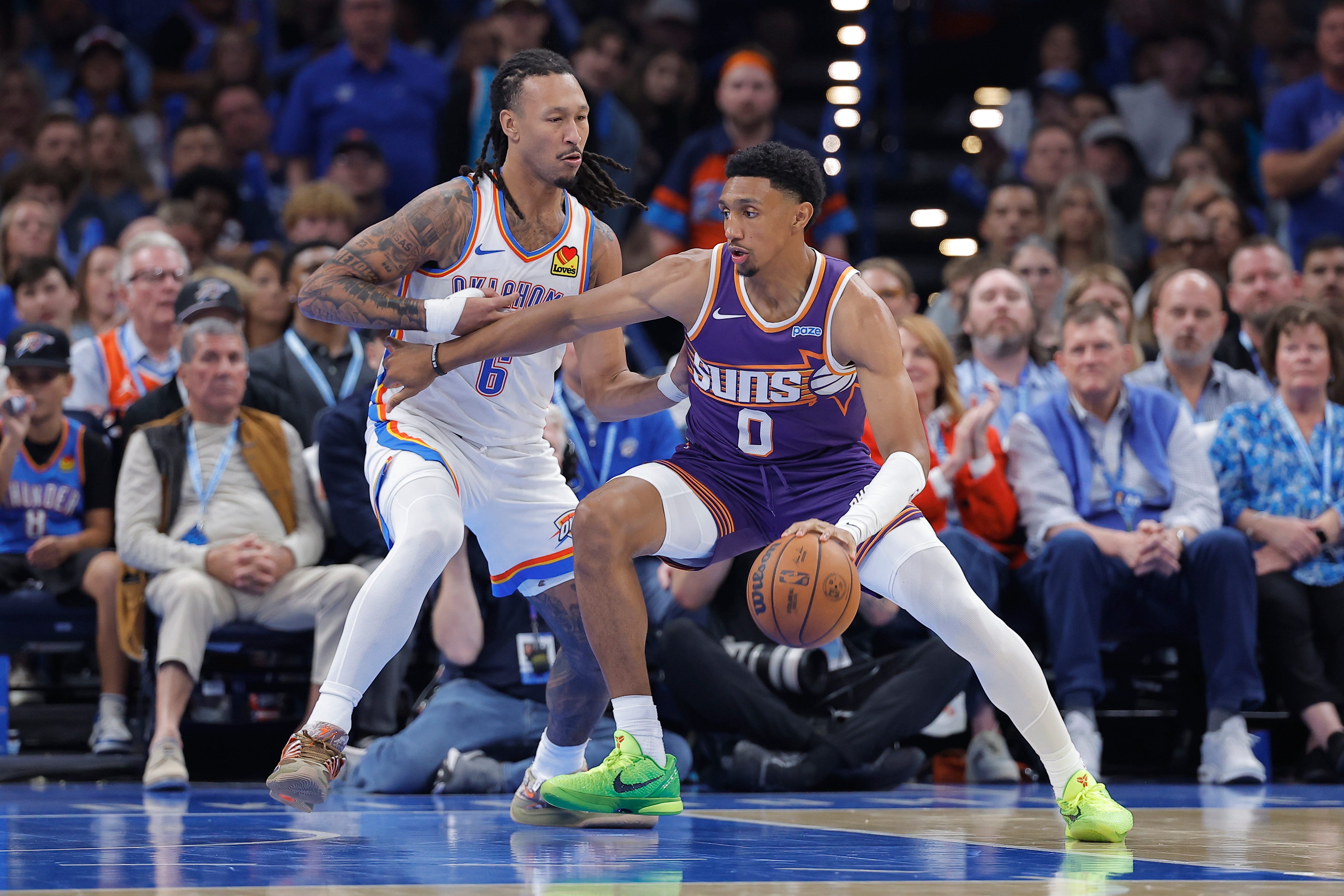 Oct 26, 2026; Oklahoma City, Oklahoma, USA; Phoenix Suns forward Ryan Dunn (0) moves the ball as Oklahoma City Thunder forward Jaylin Williams (6) defends during the second half at Paycom Center. Mandatory Credit: Alonzo Adams-Imagn Images