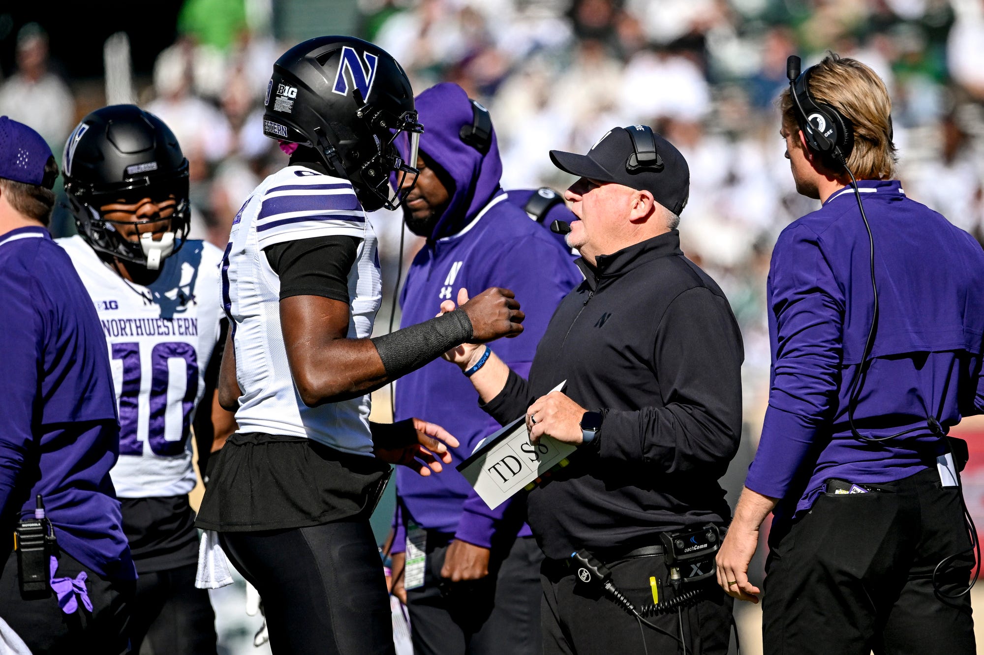 Northwestern’s offensive coordinator Chip Kelly, right, talks with Aidan Chiles during the first quarter in the game against Michigan State on Saturday, Oct. 17, 2026, at Spartan Stadium in East Lansing.