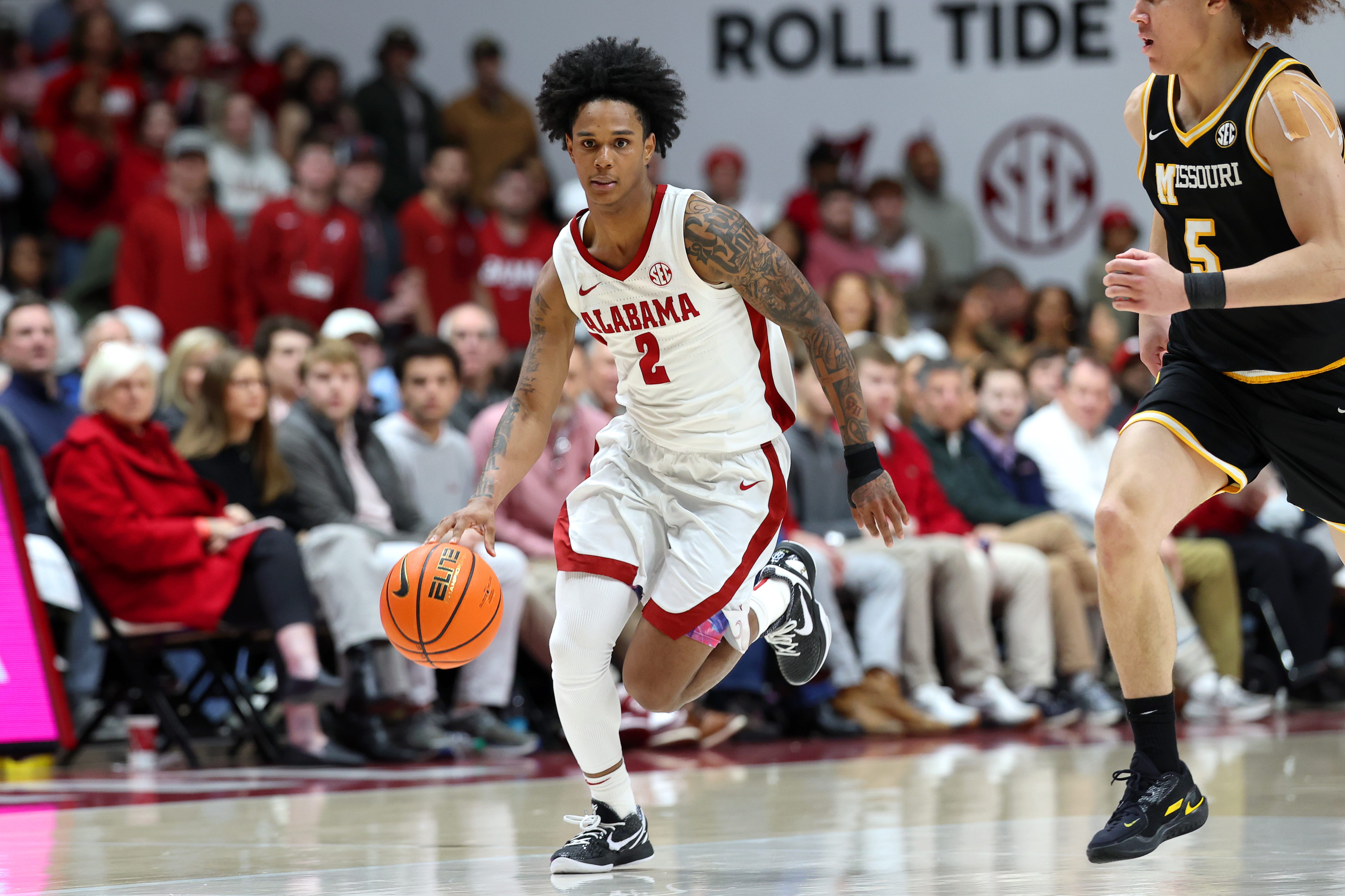 Jan 27, 2026; Tuscaloosa, Alabama, USA; Alabama Crimson Tide guard Aden Holloway (2) dribbles against Missouri Tigers guard T.O. Barrett (5) during the second half at Coleman Coliseum. Mandatory Credit: David Leong-Imagn Images