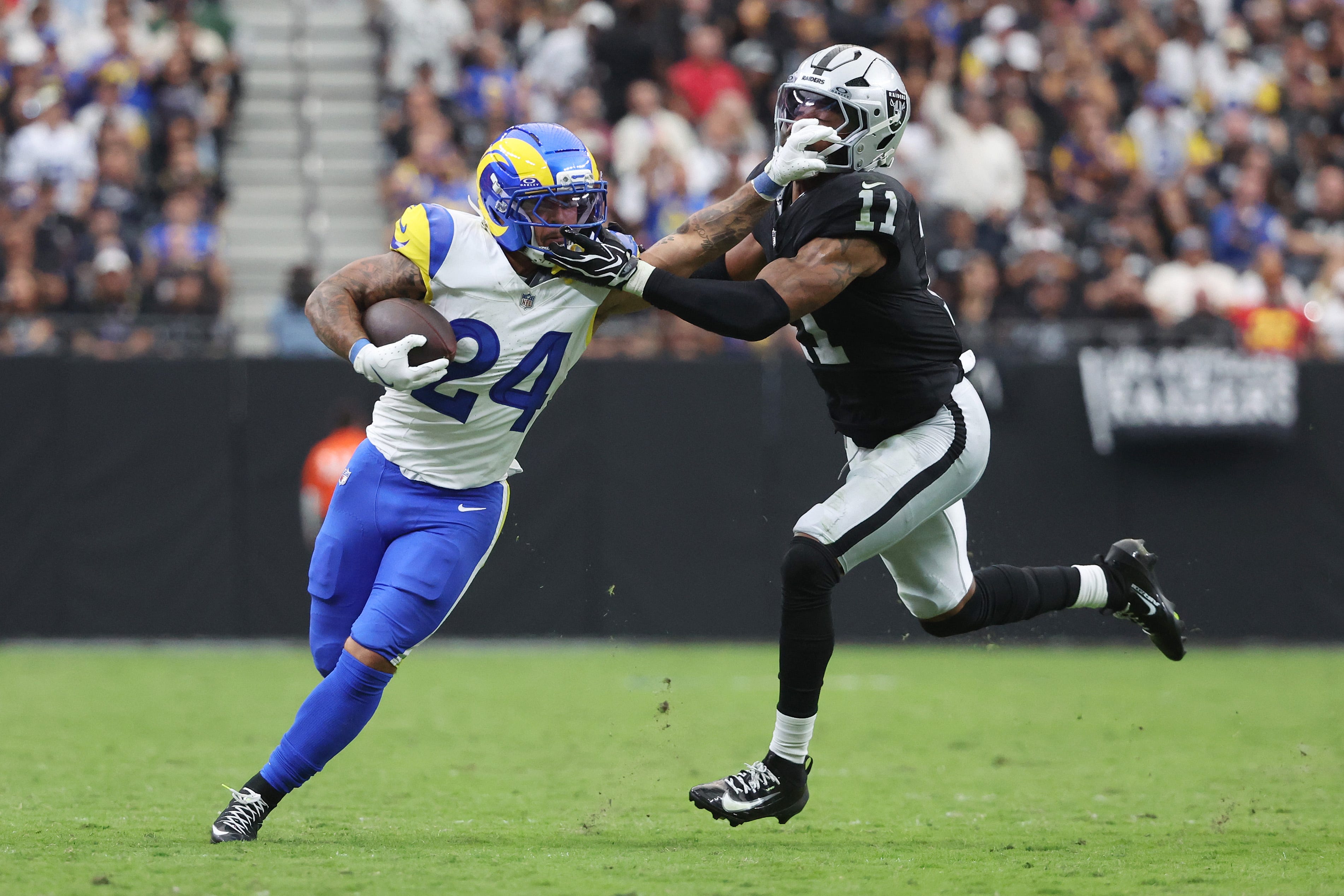 Blake Corum #24 of the Los Angeles Rams stiff arms Jeremy Chinn #11 of the Las Vegas Raiders during the second quarter at Allegiant Stadium on October 25, 2026 in Las Vegas, Nevada.